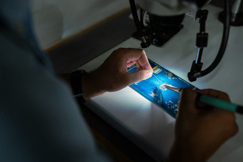 Revisión de la placa de un celular bajo luz y lupa en su comuna
